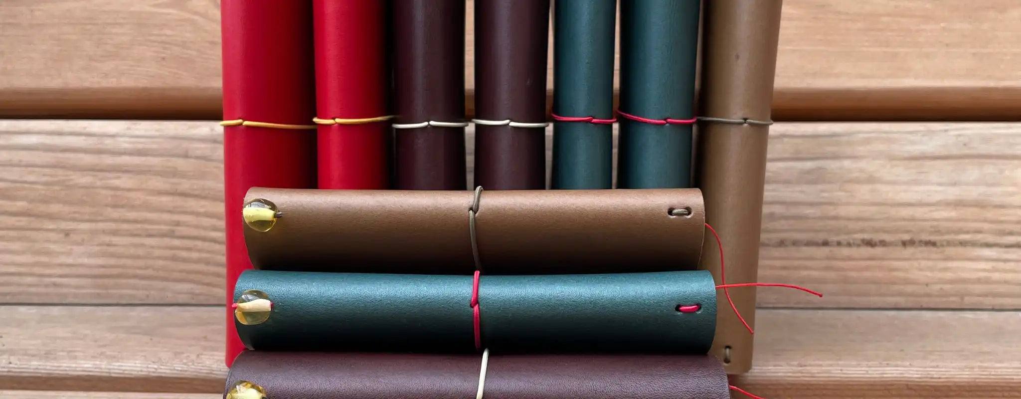 Collection of handmade leather traveler’s journals in multicolor, featuring Atlas and Vellum sizes.