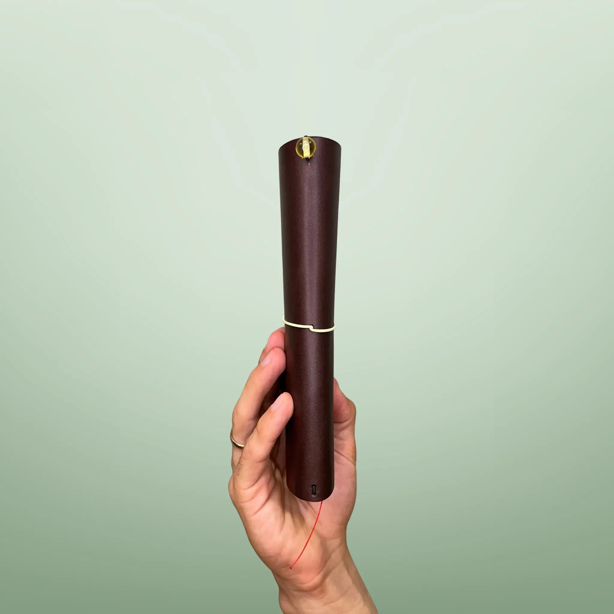 Bielinis handmade traveler’s journal Atlas in rich dark brown leather, side view highlighting genuine Baltic amber accents and fine craftsmanship.
