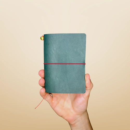 Bielinis best handmade traveler’s journal Vellum in petrol blue leather, front view featuring genuine Baltic amber accents and a compact, palm-sized design perfect for everyday adventures.