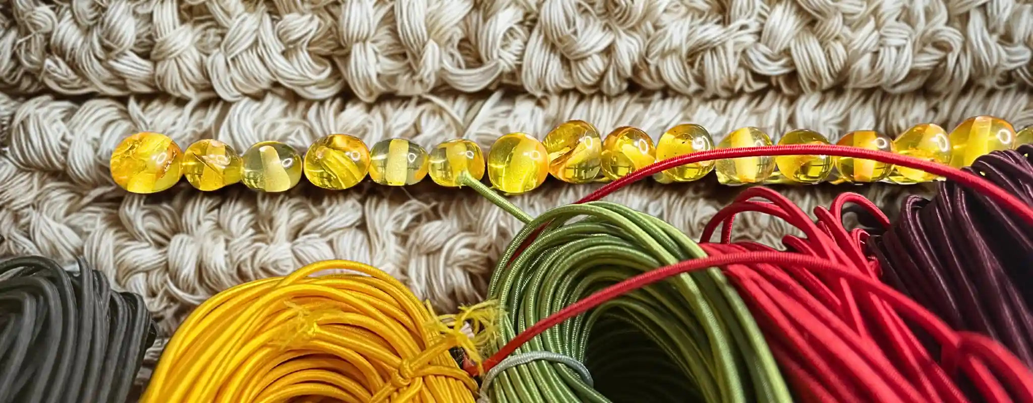 Bielinis traveler's journal accessories – elastic cords and Baltic amber charms for handmade leather notebooks.