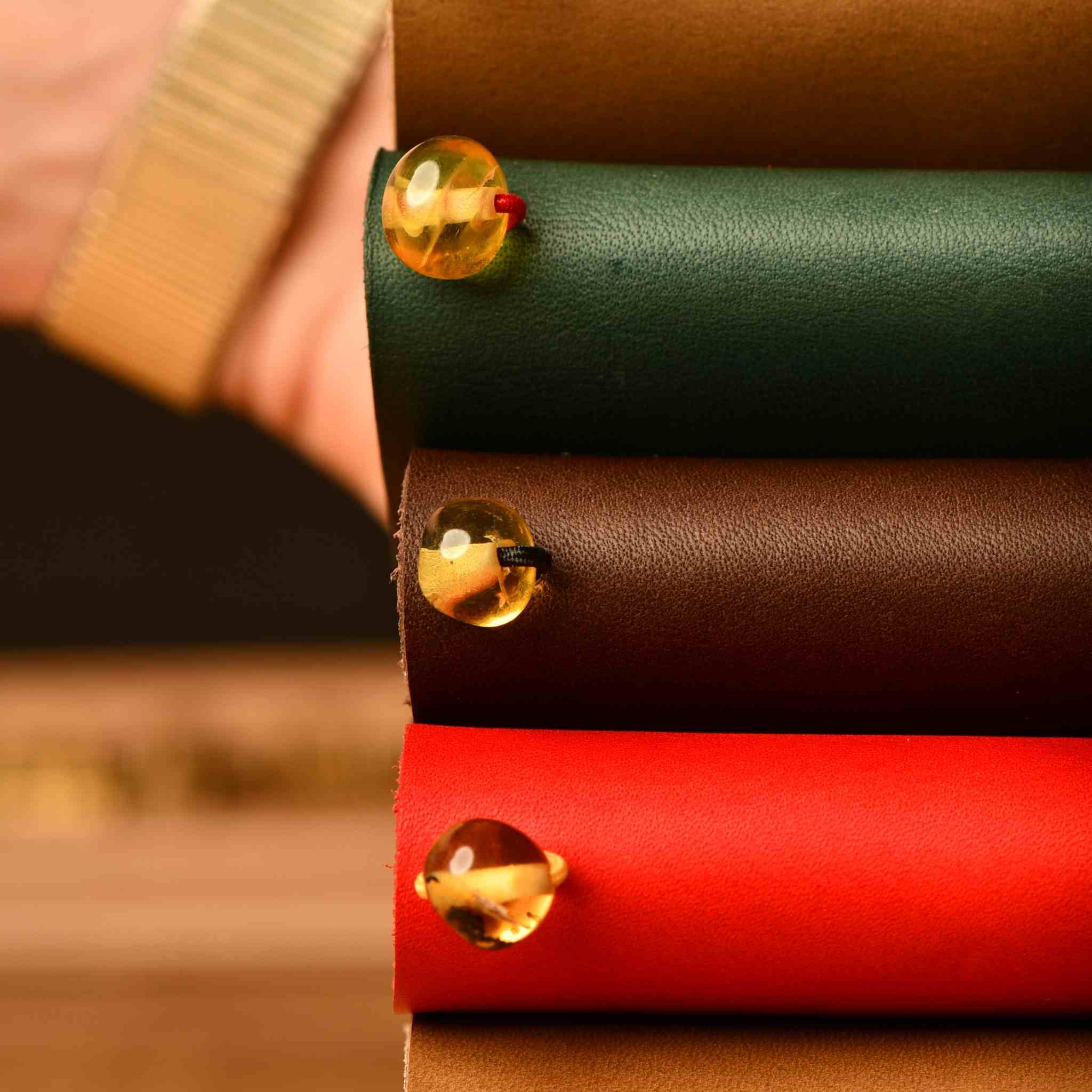 Bielinis traveler’s journal with Baltic amber charm, showcasing a handmade leather journal designed for travelers and reading lovers.