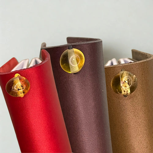 Bielinis traveler’s journal with Baltic amber charm, showcasing a handmade leather journal designed for travelers and reading lovers.