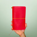 Bielinis handcrafted traveler’s journal Atlas in vibrant red leather, front view highlighting genuine Baltic amber accents and premium Italian leather quality.