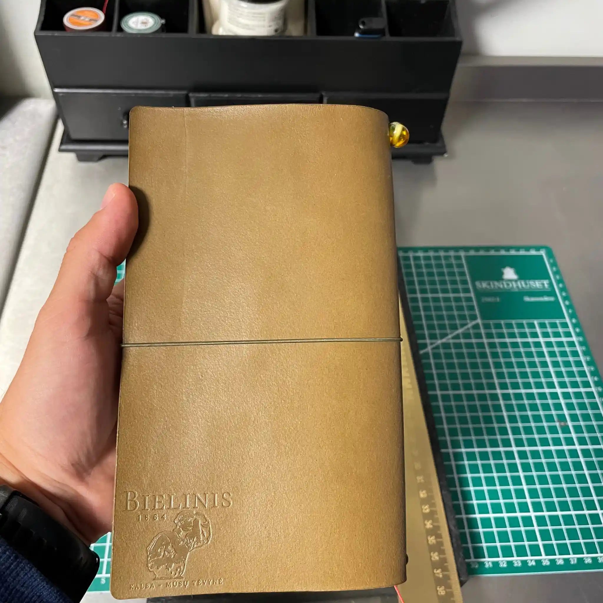 Flat lay of a Bielinis traveler’s journal designed for men with purpose, crafted from premium leather and accented with Baltic amber for durable, stylish storytelling.